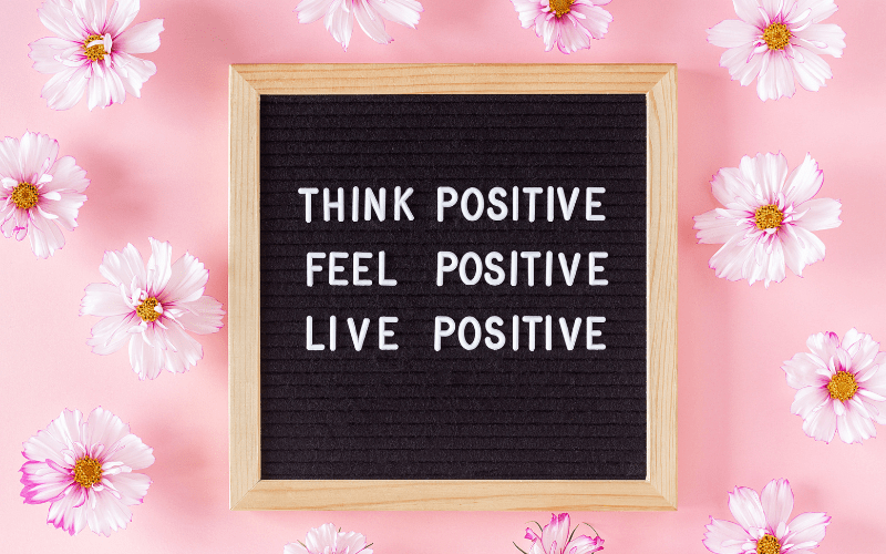 good parenting quotes: think positive, feel positive, live positive written on a black frame in white letters. There are pretty flowers in the background