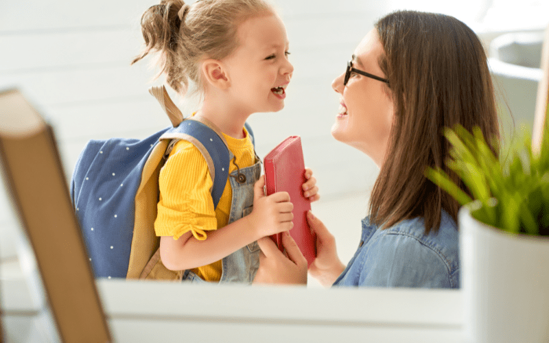 good parenting quotes a happy mother and daughter smiling while the little girl is handing her mother a red notebook