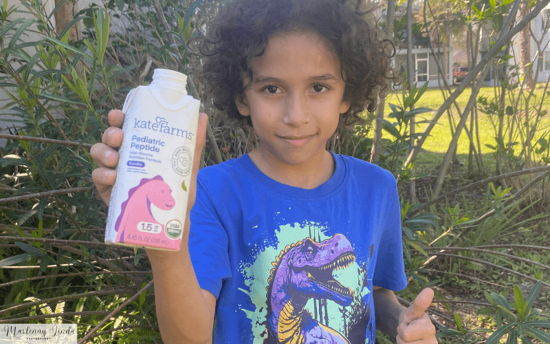 health and nutrition Kate Farms Shakes. Anthony smiling and holding his shake.