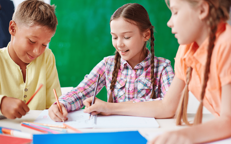 a group of kids drawing together in school