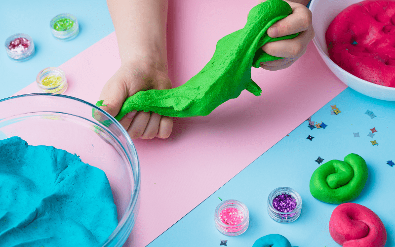 clay art ideas a child molding neon green clay and making shapeso