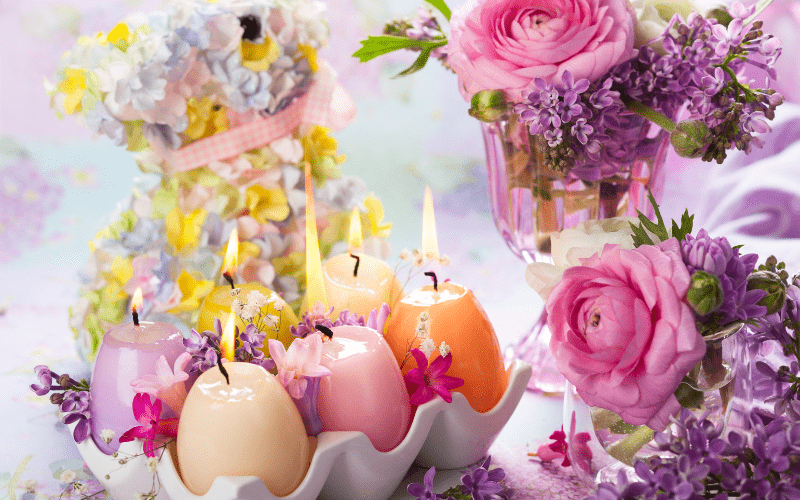 candles shaped as eggs lit in a beautiful manner decorated with flowers