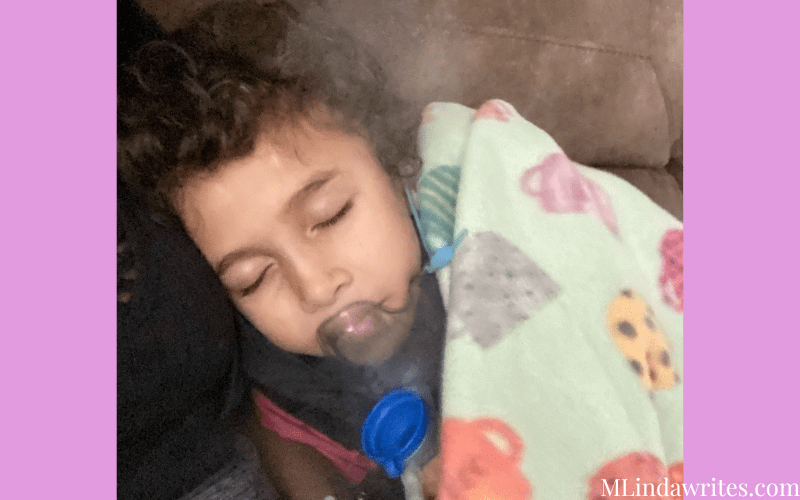 an image of a cute little boy cuddled by his mother doing his vest and breathing treatment for cystic fibrosis