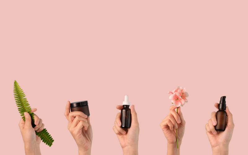 four hands holding up natural beauty products for the skin