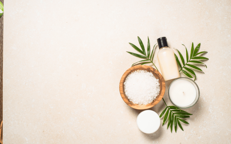 beauty products for the skin including mineral rocks and a candle jar along with a bottle of hydrating lotion